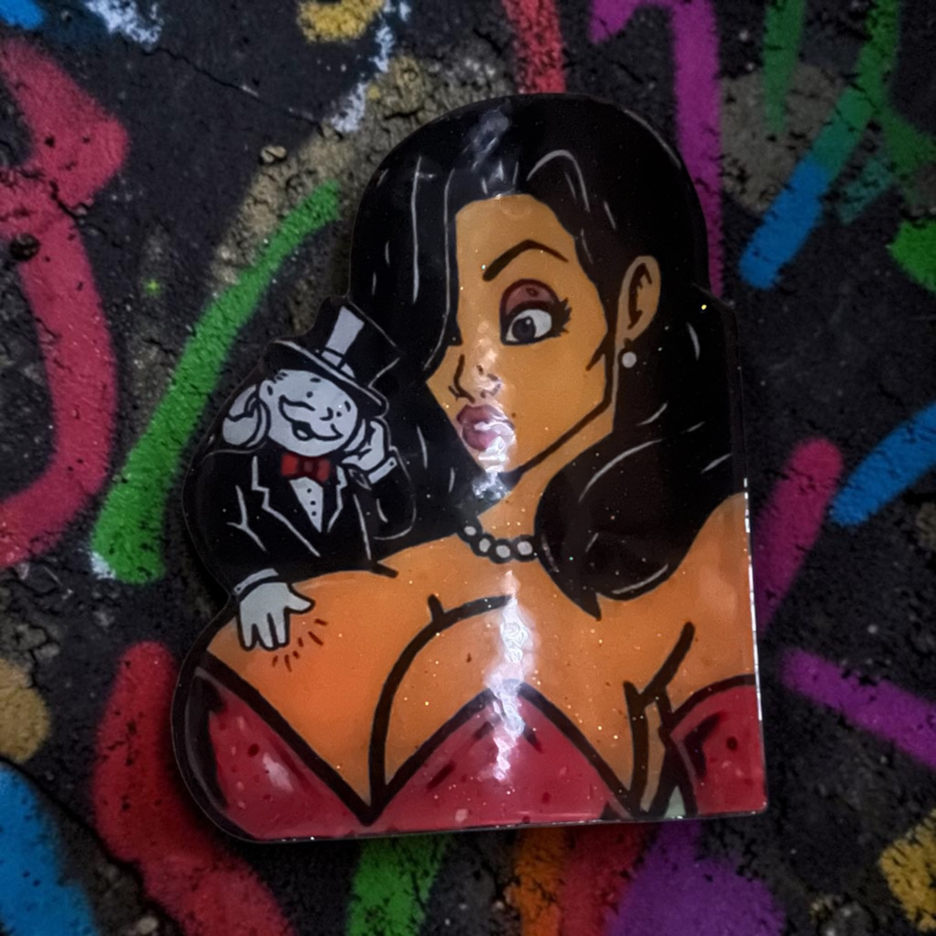 Custom hand-cut and epoxy cartoon diva wood art piece with a small suited character whispering, on a colorful graffiti background