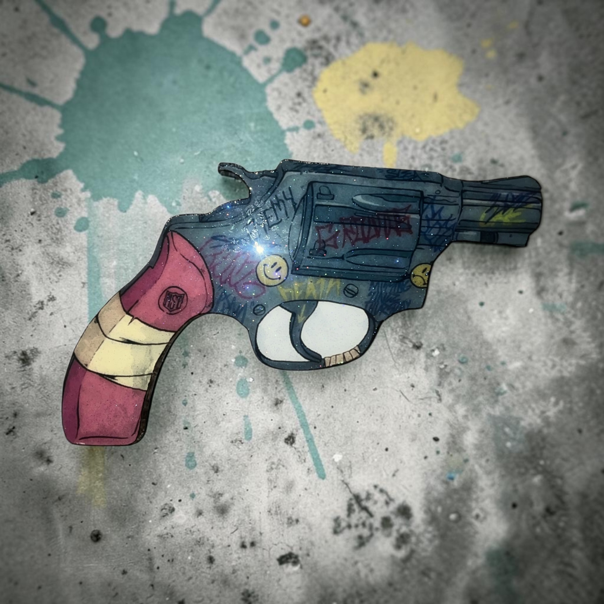 Custom hand cut revolver shaped epoxy wood wall piece with graffiti details, smiley faces, and glossy resin finish